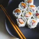 Talerz z sushi, pałeczki i dodatki. Czy sushi tuczy? Zależy od składników i ilości ryżu.