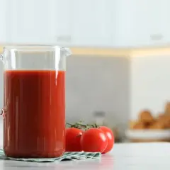 Dzbanek z sokiem pomidorowym i pomidorkami. Pamiętaj o sok pomidorowy przeciwwskazania, jeśli masz problemy z żołądkiem.