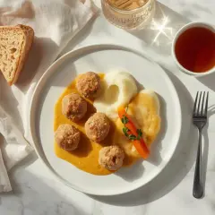Delikatne klopsiki z puree, marchewką i sosem – idealne danie, co można jeść na diecie lekkostrawnej. Do tego kromka chleba i herbata.