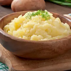 Puszyste puree ziemniaczane w drewnianej misce, ozdobione koperkiem. Idealne jako alternatywa dla masła, gdy zastanawiasz się, co dodać do ziemniaków.