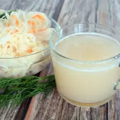 Szklanka z sokiem z kiszonej kapusty i miska z samą kapustą, idealne na dietę.