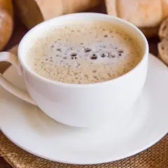 Kawa zbożowa z mlekiem, otoczona pieczywem i ciasteczkami, to zdrowa alternatywa dla tradycyjnej kawy.