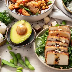 Kolorowe dania, w tym hummus, ryż, awokado i grillowane tofu, idealne do diety bogatej w błonnik przepisy.
