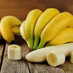 Pęczek dojrzałych bananów, jeden obrany, kilka plasterków. Idealny, duży banan kcal na zdrową przekąskę.