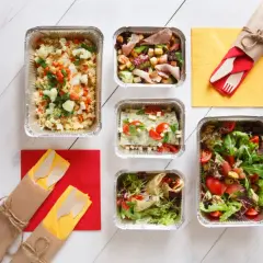Pięć pudełek z jedzeniem, w tym sałatki i dania główne, gotowe do odbioru. Zastanawiasz się, ile kosztuje dieta pudełkowa?