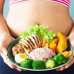 Zdrowa dieta to klucz do tego, jak szybko pozbyć się brzucha. Na talerzu grillowany kurczak, ryż, warzywa i jajko.