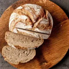 Chleb żytni na zakwasie, pokrojony na desce, to dobry wybór, jeśli szukasz pieczywa, jakie pieczywo ma najmniej kalorii.