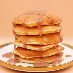 Stos puszystych naleśników polanych sosem. Czy pancake są zdrowe? Zależy od składników i dodatków!