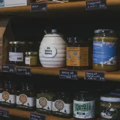Słoiki z miodem, idealne na keto, na półce sklepowej. Różne rodzaje miodu, w tym "Honing uit Oosterwold".