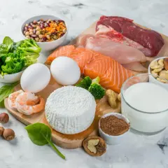 Różnorodne produkty z białkiem: mięso, ryba, jajka, nabiał, orzechy, nasiona, krewetki i warzywa.
