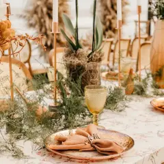 Stół weselny z dekoracjami, kwiatami i zastawą stołową w stylu boho.