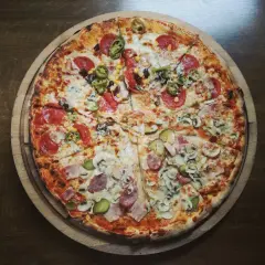 Apetyczna pizza na cienkim cieście z różnymi dodatkami: salami, pieczarki, kukurydza, papryczki jalapeno i ogórek. Zastanawiasz się, ile kalorii ma pizza na cienkim cieście?