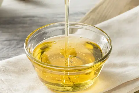Złocisty syrop glukozowy w miseczce. Czy syrop glukozowy jest zdrowy? To pytanie nurtuje wielu konsumentów.