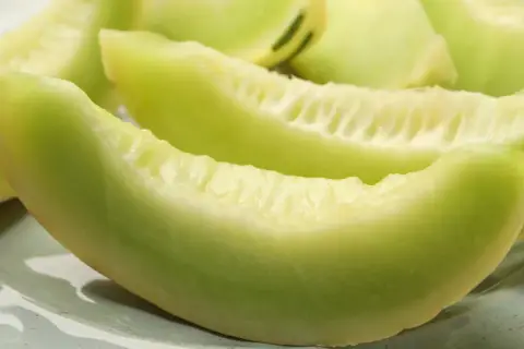 Soczyste kawałki zielonego melona na talerzu. Czy melon jest lekkostrawny? Tak, to świetny wybór na zdrową przekąskę.