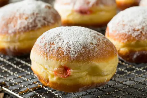 Puszyste pączki z dżemem, posypane cukrem pudrem, idealne jako zdrowe pączki dla dzieci.