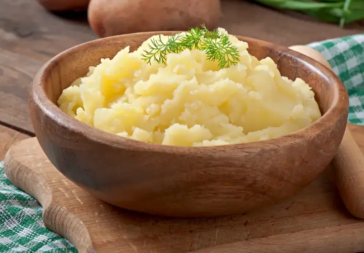 Puszyste puree ziemniaczane w drewnianej misce, ozdobione koperkiem. Idealne jako alternatywa dla masła, gdy zastanawiasz się, co dodać do ziemniaków.