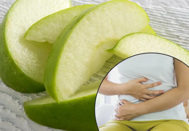 Kawałki zielonych jabłek i kobieta trzymająca się za brzuch, sugerujące związek między jabłkami a refluksem.
