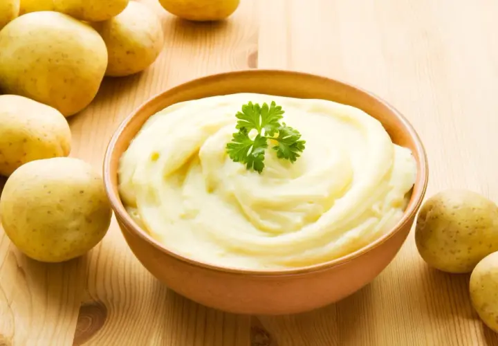 Aksamitne puree ziemniaczane, ozdobione natką pietruszki, obok świeżych ziemniaków. Idealne jako dodatek do obiadu.