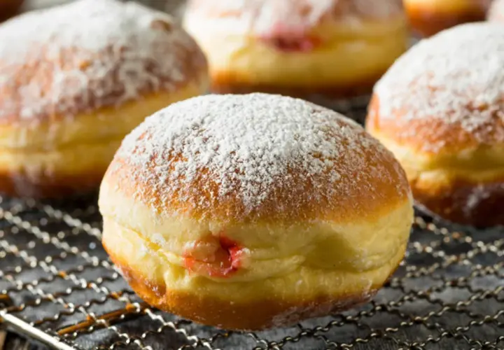Puszyste pączki z dżemem, posypane cukrem pudrem, idealne jako zdrowe pączki dla dzieci.