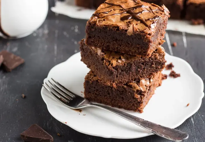Stos puszystych brownie na talerzyku, idealne na zdrowe przekąski. Szukasz ciasta fit przepisy? Oto one!