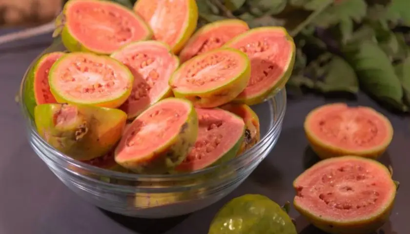 Kusząca guawa jak jeść? Pokrojone owoce w misce i na blacie, gotowe do degustacji.