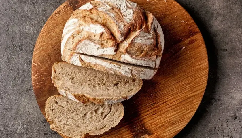 Chleb żytni na zakwasie, pokrojony na desce, to dobry wybór, jeśli szukasz pieczywa, jakie pieczywo ma najmniej kalorii.