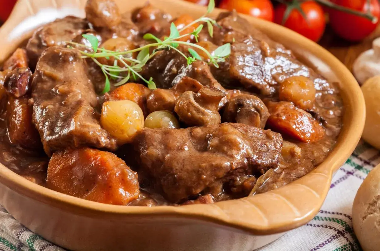 Gulasz wołowy z pieczarkami i cebulką, idealny przykład, jak przyrządzać wołowinę. Aromatyczne danie w glinianej misie.
