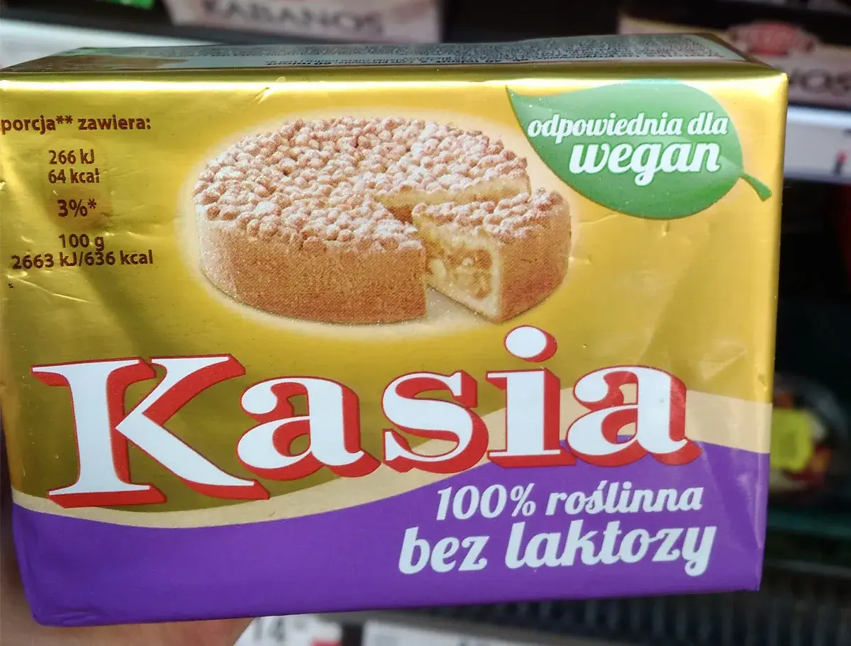 Opakowanie margaryny "Kasia" z wizerunkiem ciasta. Produkt jest 100% roślinny i odpowiedni dla wegan.