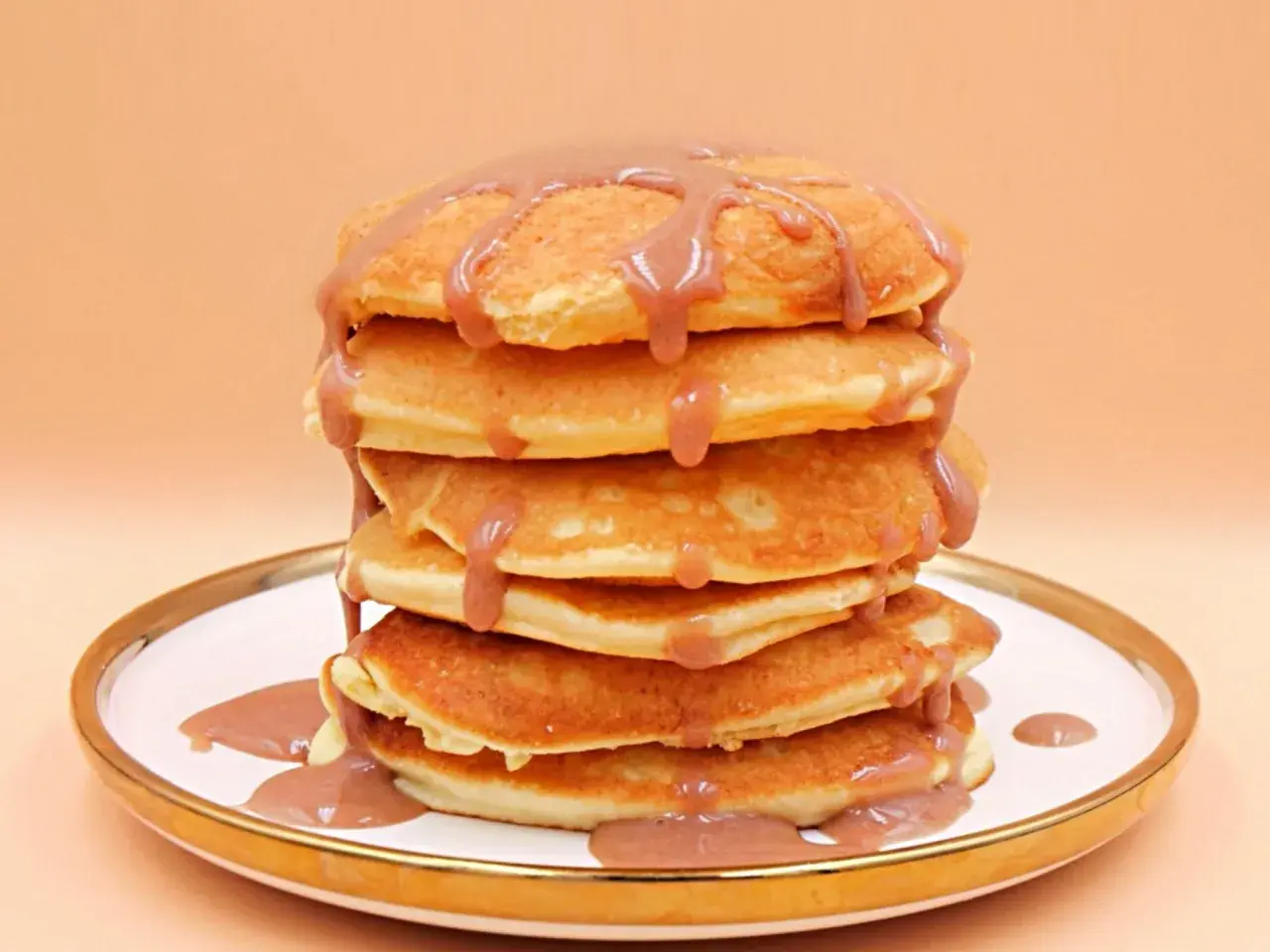 Stos puszystych naleśników polanych sosem. Czy pancake są zdrowe? Zależy od składników i dodatków!