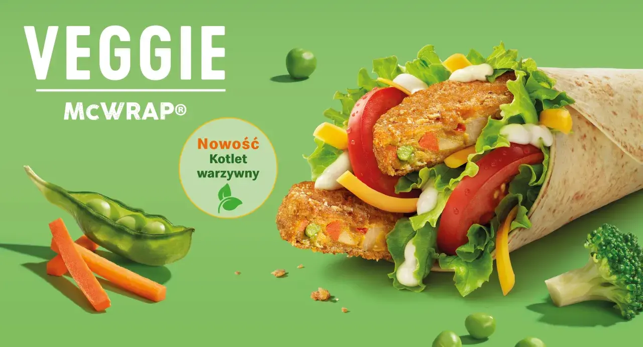 Veggie McWrap z kotletem warzywnym, sałatą, pomidorem, serem i sosem. Widać też groszek, marchewkę i brokuł.
