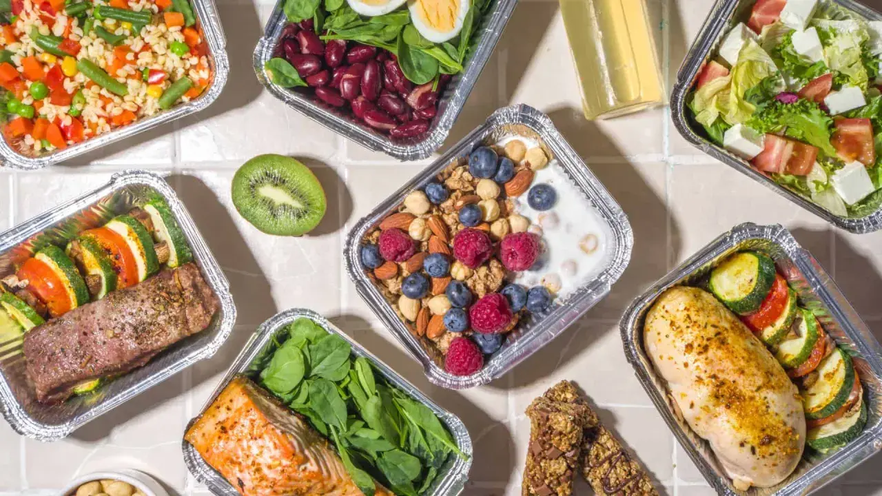 Różnorodne posiłki w pudełkach: łosoś, kurczak, sałatka, owsianka z owocami. Sprawdź, jakie są dieta pudełkowa koszty i wybierz zdrowy catering!