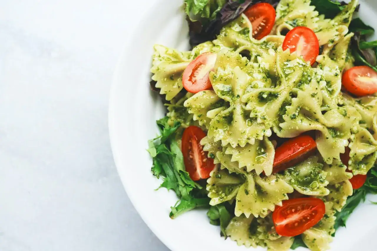 Makaron farfalle z pesto, pomidorkami koktajlowymi i świeżą sałatą. Idealny zdrowy i szybki obiad.