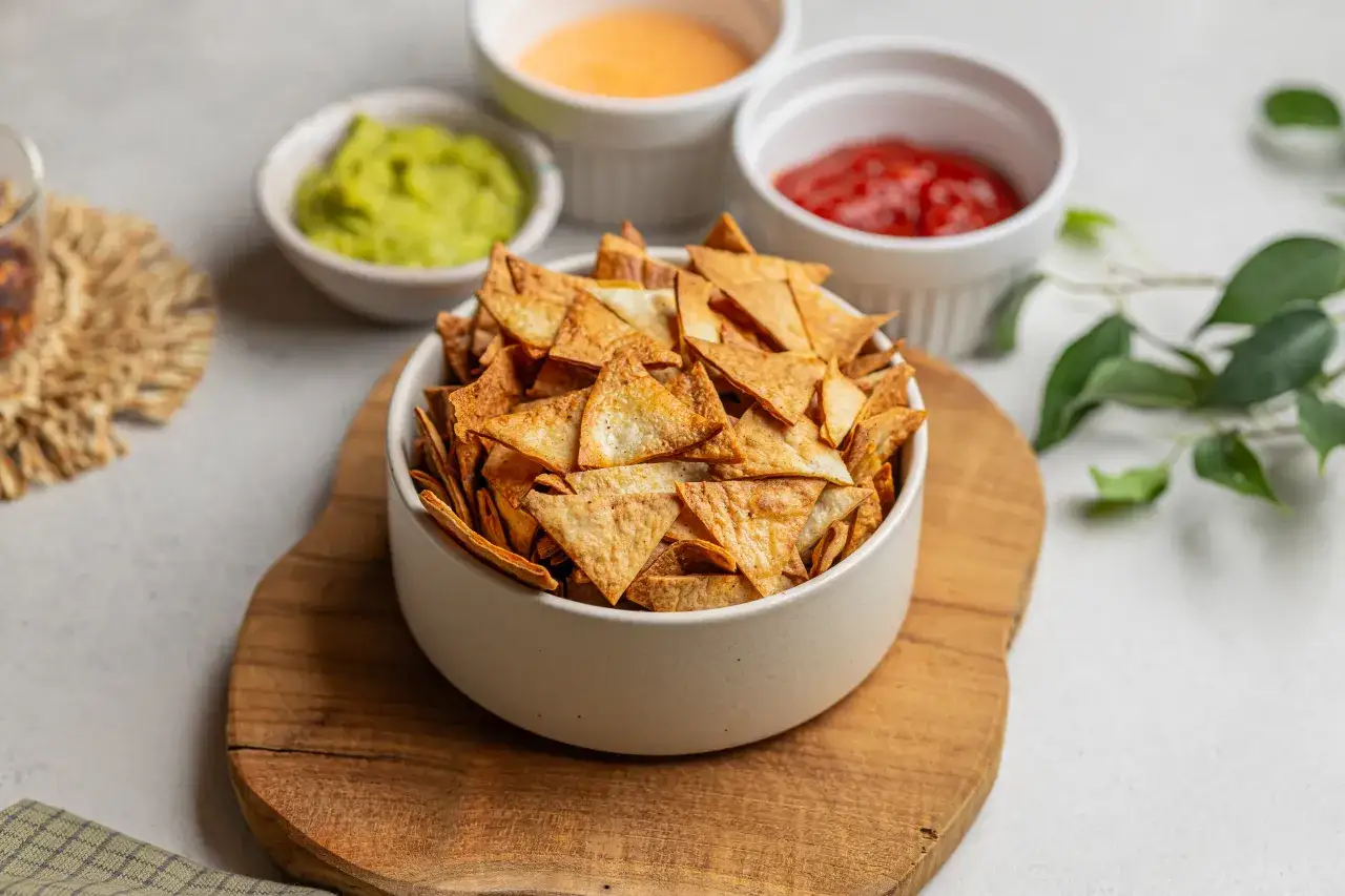 Chrupiące chipsy tortilla z guacamole, serem i salsą. Czy chipsy tortilla są zdrowe? Zależy od sposobu przygotowania i dodatków!