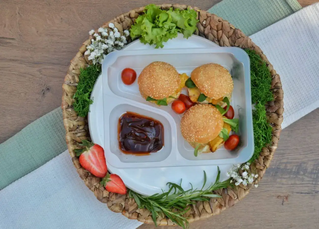 Idealny catering dla par: trzy mini burgery z sezamem, sos barbecue, pomidorki i truskawki.