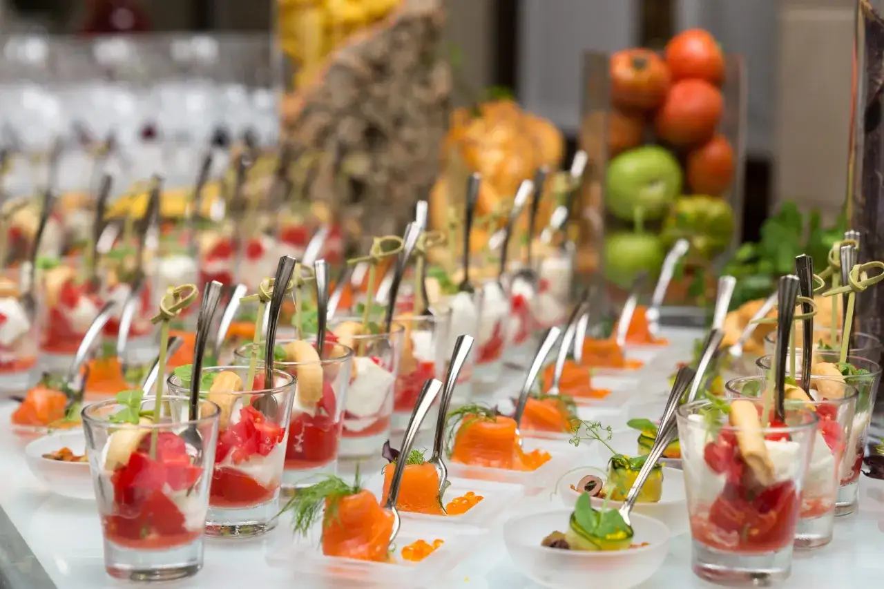 Eleganckie przekąski na imprezie pokazują, jak działa catering: małe porcje, estetyczne podanie, różnorodność smaków.