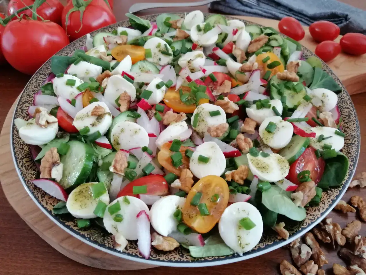 Kolorowa sałatka z kulkami mozzarelli, pomidorkami, ogórkiem, rzodkiewką i orzechami. Zastanawiasz się, ile kcal ma kulka mozzarelli w takiej kompozycji?