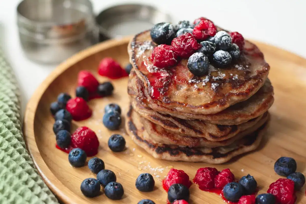 Stos zdrowych naleśników z jagodami i malinami. Czy pancake są zdrowe? Z owocami i bez dodatku cukru, mogą być!