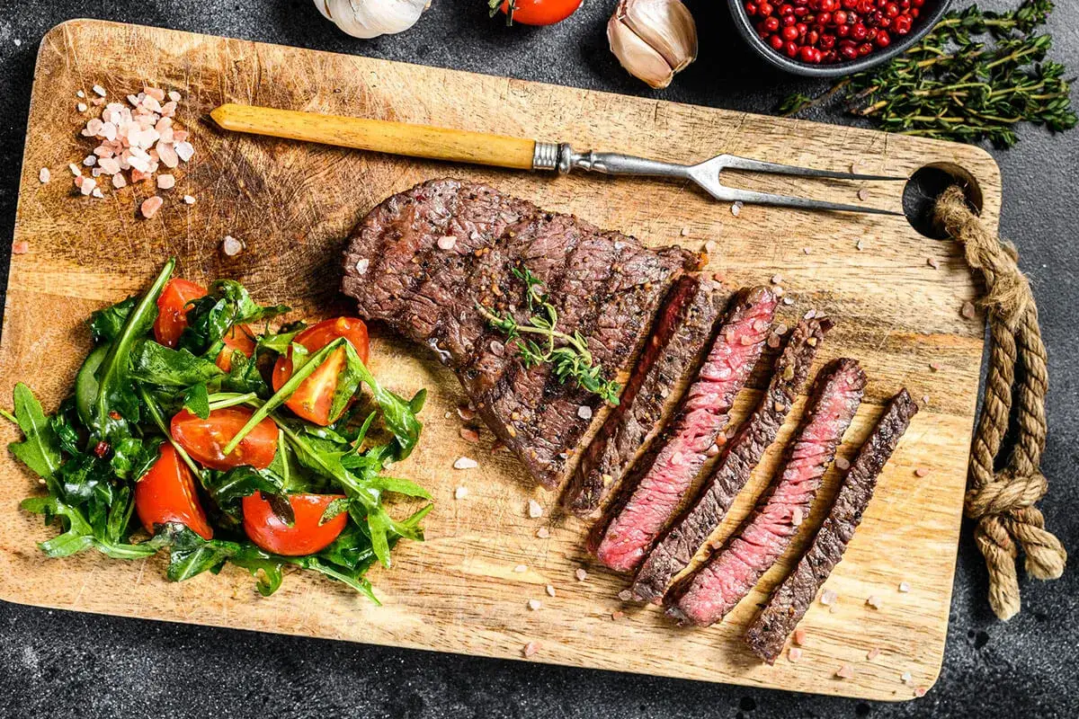 Idealny stek na talerzu, idealny na dietę karniwora co jeść. Soczyste mięso, rukola i pomidorki.