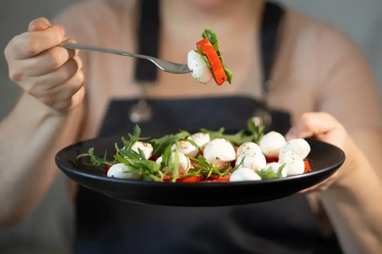 Sałatka caprese z kulkami mozzarelli, pomidorami i rukolą. Czy mozzarella podnosi cukier? Ten lekki posiłek to dowód, że zdrowe jedzenie może być pyszne.