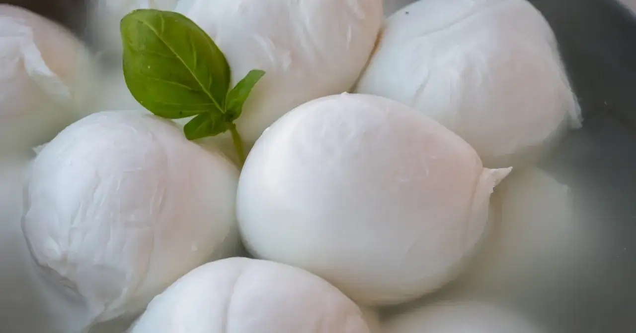 Kulki mozzarelli w wodzie, z listkiem bazylii. Czy mozzarella jest dobra na odchudzanie? To zależy od ilości i sposobu przygotowania.