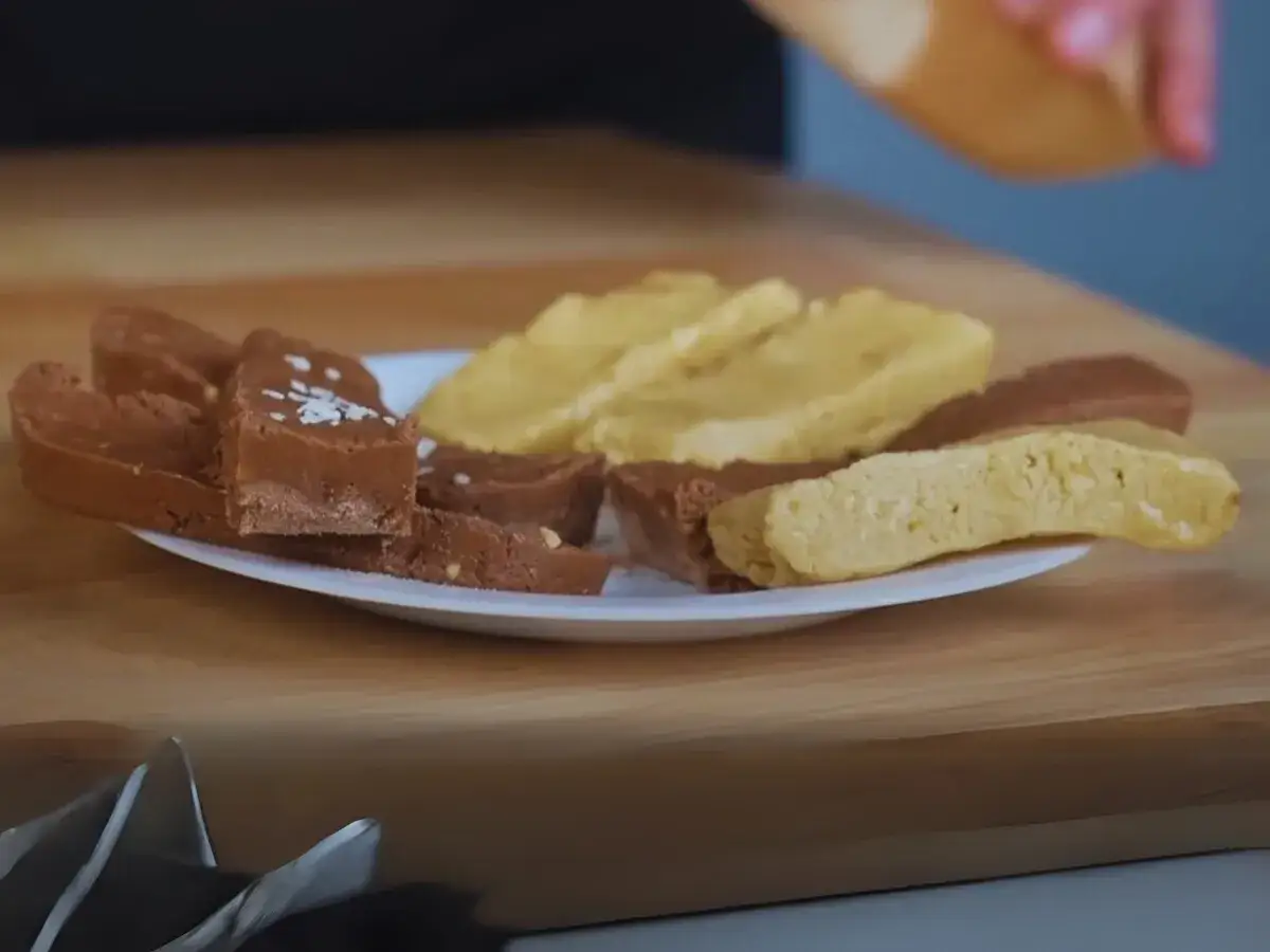 Czekoladowe i jasne batoniki na talerzu. Czy sezam jest keto? Te słodkości wyglądają na idealne na dietę ketogeniczną.