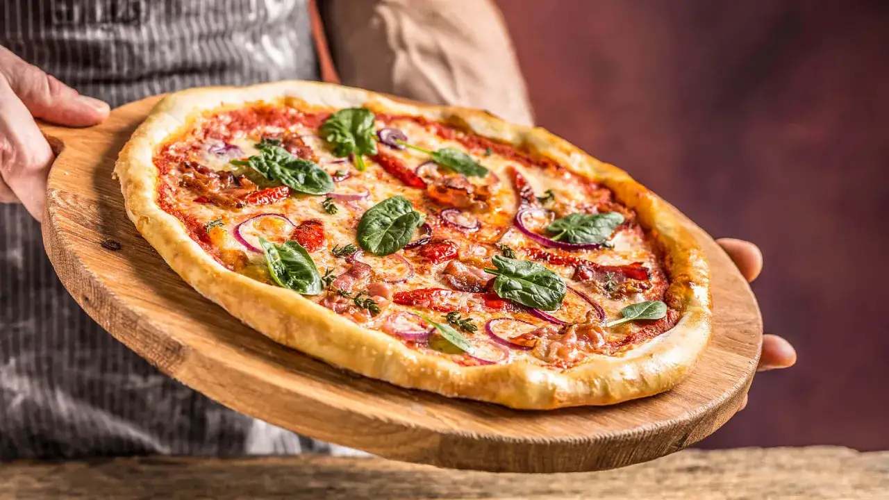 Pyszna pizza na cienkim cieście z szpinakiem i cebulą. Zastanawiasz się, ile kalorii ma pizza na cienkim cieście?