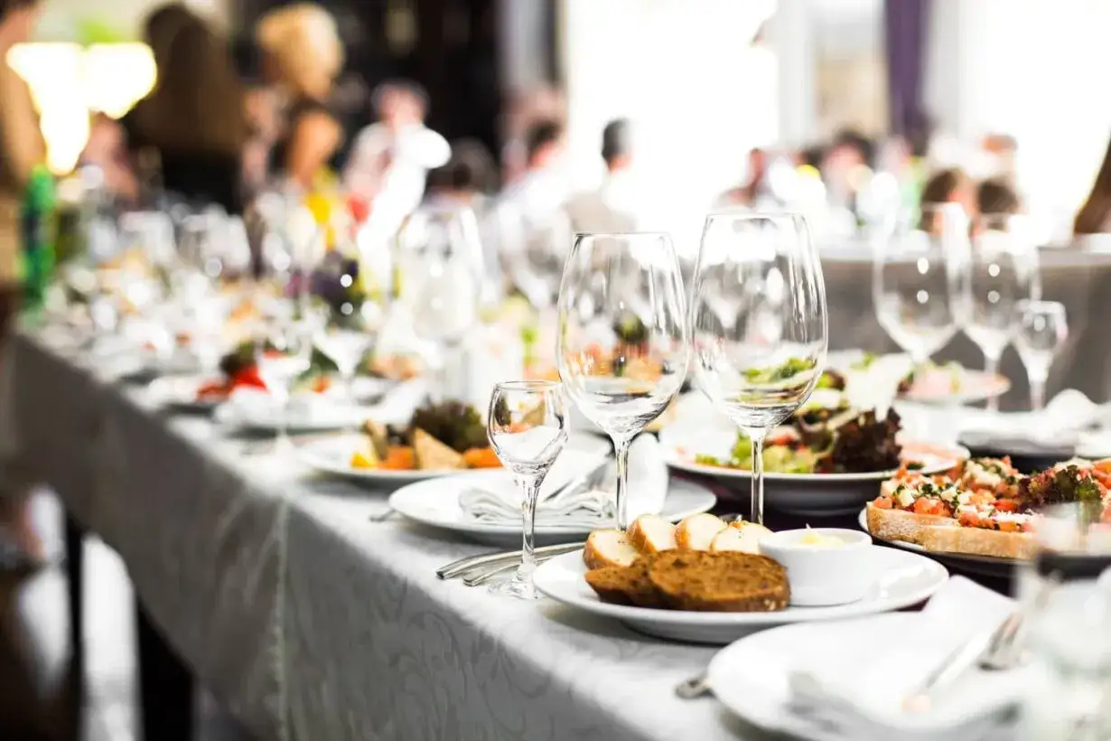 Elegancko nakryty stół z jedzeniem i kieliszkami, pokazujący, jak działa catering na przyjęciu.
