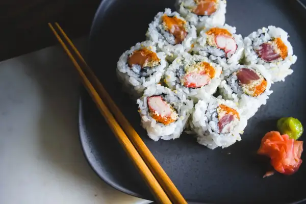 Talerz z sushi, pałeczki i dodatki. Czy sushi tuczy? Zależy od składników i ilości ryżu.